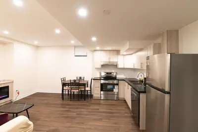 a kitchen with a stainless steel refrigerator and a table at New Basement Apartment with parking in Oakville