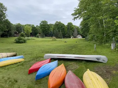 a group of different colored surfboards on the grass at Stunning Lakeview Muskoka Pier 100 Resort in Port Carling