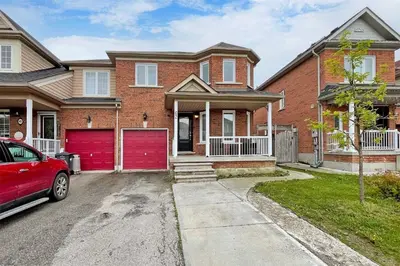 a red brick house with a red garage at Large Family Favorite Spacious 6-Bedroom Home in Brampton