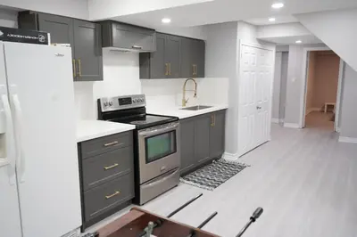 a kitchen with gray cabinets and a stove at Large Family Favorite Spacious 6-Bedroom Home in Brampton