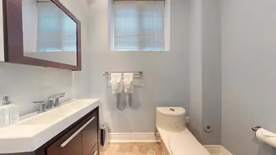 a white bathroom with a sink and a toilet at Modern & Spacious Midtown Toronto Family Home in Toronto