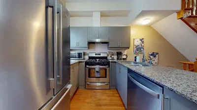 a kitchen with stainless steel appliances and a counter top at Modern & Spacious Midtown Toronto Family Home in Toronto