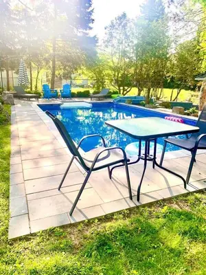 a table and chairs next to a swimming pool at The Serenity Home Pool/Yoga/Game Room by the Lake in Mississauga