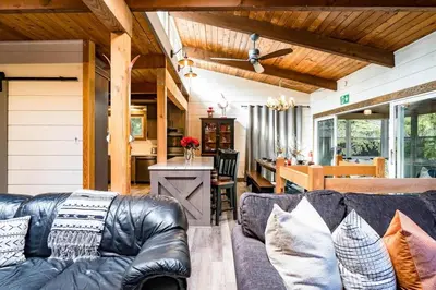 a living room with a leather couch and a kitchen at Cozy upgraded Chalet Hot Tubs Sauna Fireplace in Blue Mountains