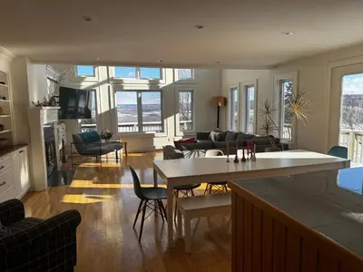 a kitchen and living room with a table and chairs at Beaver Valley Farmhouse with Pool & Stunning Views in Kimberley