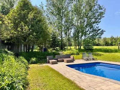 a backyard with a swimming pool with two lounge chairs at Beaver Valley Farmhouse with Pool & Stunning Views in Kimberley