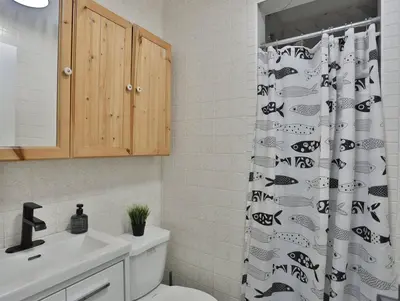 a bathroom with a black and white shower curtain at Cozy Georgian Bay Cottage Firepit, Beach, 4-Season in Tiny