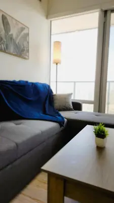 a living room with a couch and a table at Toronto Lakeview by TMU & UofT with Pool, Gym & Parking in Toronto
