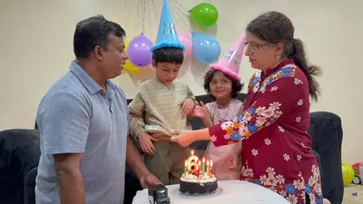 a man and a woman and a boy with a birthday cake at Luxury room at southern Guelph in Guelph