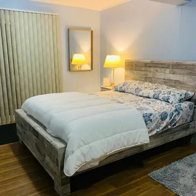 a bedroom with a large bed with a wooden headboard at Rice Lake Retreat 2 Bed Home 16 Ft Swim spa Sauna in Bailieboro