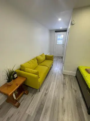 a living room with a yellow couch and a table at DOWNTOWN-BMO Field Stay-Next to Transit-Restaurants-Union Station in Toronto