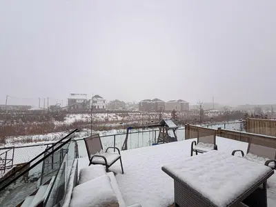 a balcony covered in snow with a table and chairs at Blessed Home in Milton