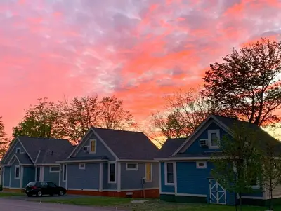 a house with a sunset in the sky at The Bluebird - 7 Summer Village in Cherry Valley