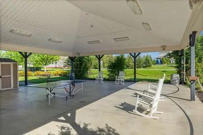 a large covered patio with a table and chairs at The Bluebird - 7 Summer Village in Cherry Valley