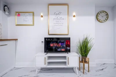 a tv sitting on top of a white cabinet at Bright Modern 1BR Suite Kitchen Workspace Smart TV in Bowmanville