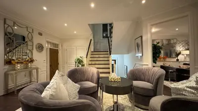 a living room with chairs and a table and a staircase at Executive Luxury Stay Corporate Paradise in South Richvale in Richmond Hill