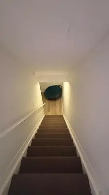 a stairway with a green pillow on the floor and a stair case at Grimsby on the Lake sweet, your perfect retreat in Grimsby