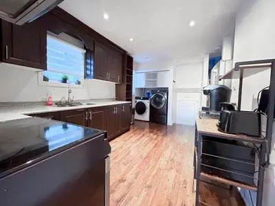 a kitchen with wooden floors and a kitchen with a counter top at Executive Urban Retreat in Brampton