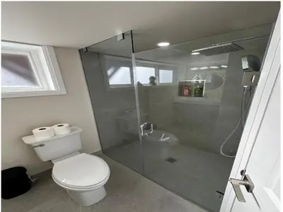 a bathroom with a toilet and a glass shower at Modern 2 bedrooms 1 bath updated unit Near Downtown Kitchener & Airport in Kitchener