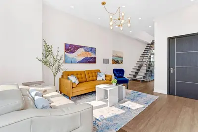 a living room with a yellow couch and a blue chair at Winter Deal! Modern 4BR w/Parking, Prime Location in Toronto