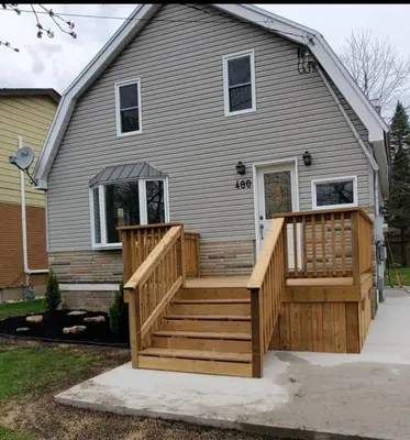 a house with a large wooden deck on a house at Getaway by the bay in Owen Sound