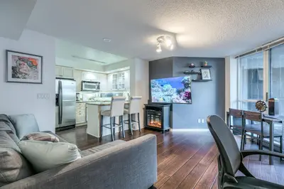 a living room with a couch and a fire place at Downtown 1BR Condo w/ Balcony & Gym Access in Toronto