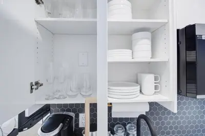 a kitchen with white cabinets and plates and a sink at 2 Bed Newly Renovated unit near Falls and Buffalo in Port Colborne