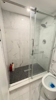 a shower stall in a bathroom with a toilet at 2 Bed Newly Renovated unit near Falls and Buffalo in Port Colborne