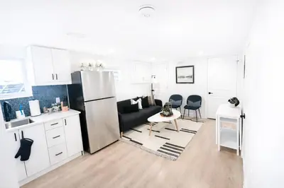 a kitchen with a refrigerator and a table and chairs at 2 Bed Newly Renovated unit near Falls and Buffalo in Port Colborne