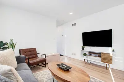 a living room with a couch and a flat screen tv at Stylish 3BR Steps to Canal, Easy Drive to Falls in Port Colborne