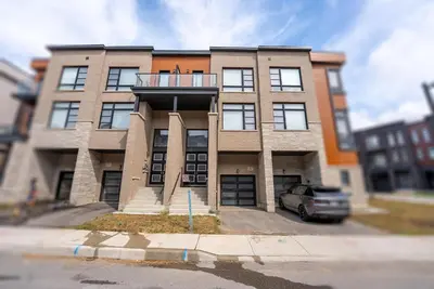 a building with a car parked in front of it at Modern Vaughan Retreat, 10 mins to Pearson Airport, Vaughan Mall in Vaughan