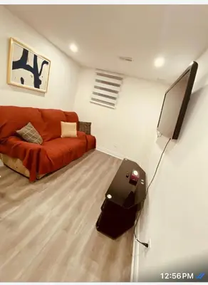a living room with a couch and a flat screen tv at Cedar Hedge Private Basement Apartment in Milton