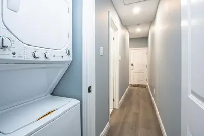 a laundry room with a washer and dryer and a hallway at Designer 2BR Suite - Steps to Vic Hospital - Wortley in London