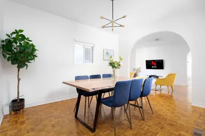 a dining room with a wooden table and blue chairs at Charming 4 Bed Home + 2Parking in Toronto