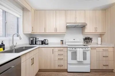 a kitchen with white appliances and wooden cabinets at Charming 4 Bed Home + 2Parking in Toronto