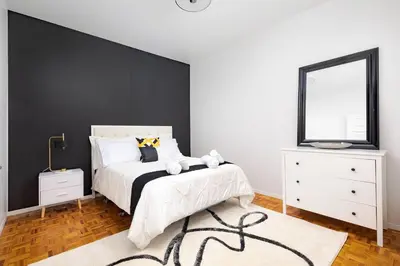 a bedroom with a white bed and a black wall at Charming 4 Bed Home + 2Parking in Toronto