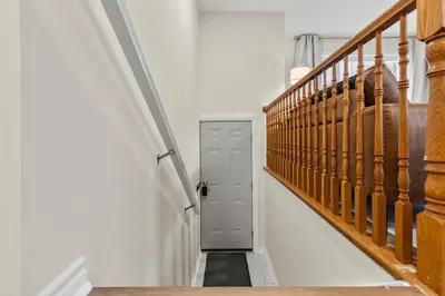 a hallway with a gray door and stairs at Chelsea Suite 3BR, 1B with parking for 28plus stays in St. Catharines