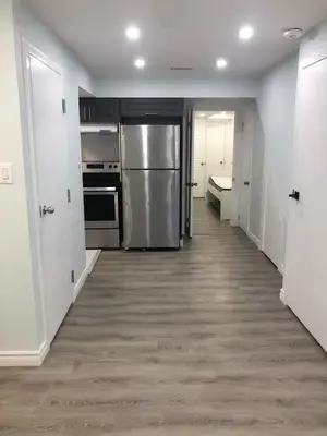 a kitchen with stainless steel appliances and a hallway at Modern Luxury Private Suite with Parking - Mississauga in Mississauga