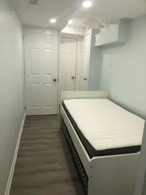 a small room with a bed and two doors at Modern Luxury Private Suite with Parking - Mississauga in Mississauga