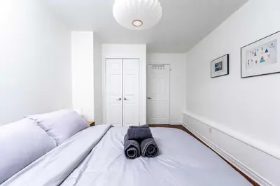 a bedroom with a white bed with a pair of goggles on it at Contemporary 1BR Basement Suite with Private Entrance in Toronto