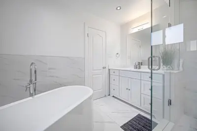 a white bathroom with a tub and a sink at 166 Main - Family Getaway 5BR Home with Backyard & Parking in Markham