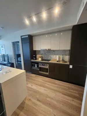 a kitchen with white cabinets and a wooden floor at Luxury 2 Bed Apartment In Vaughan Near Wonderland! in Vaughan