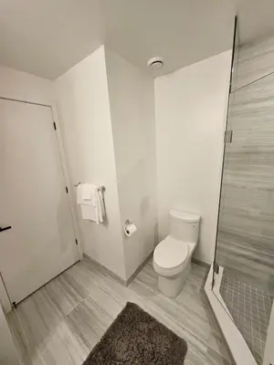 a white bathroom with a toilet and a shower at Luxury 2 Bed Apartment In Vaughan Near Wonderland! in Vaughan