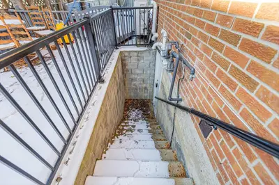 a stairway leading up to a brick wall at 166 Basement - Cozy 3BR Markham Stay, Patio, Parking, Pet-Free in Markham