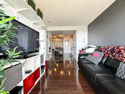 a living room with a black leather couch and a flat screen tv at CityPlace Lofts Free Parking in Toronto