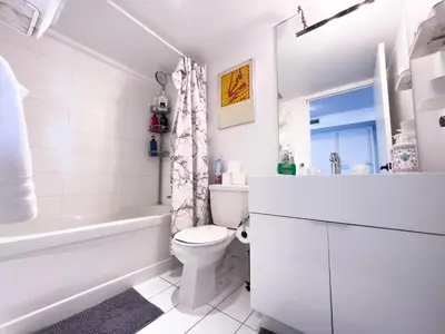 a white bathroom with a tub and a toilet and a sink at CityPlace Lofts Free Parking in Toronto