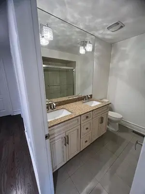 a bathroom with a sink and a toilet and a mirror at Warm Stylish 4 Bedroom Home 3 Bath in Ajax