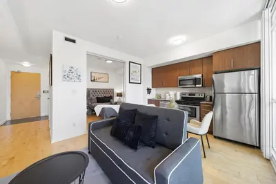 a living room with a couch and a kitchen at Downtown Toronto CN Tower Condo in Toronto