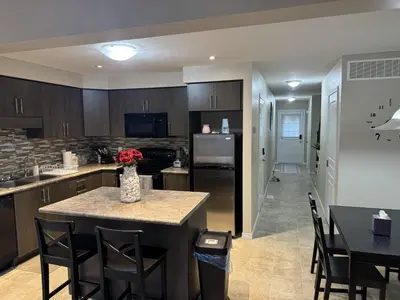 a kitchen with a table and chairs and a refrigerator at Gorgeous 3-Bedroom 3Bathroom house in Kitchener