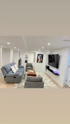 a living room with a couch and a tv at Studio 8848 - Sleeps 8 in Brampton